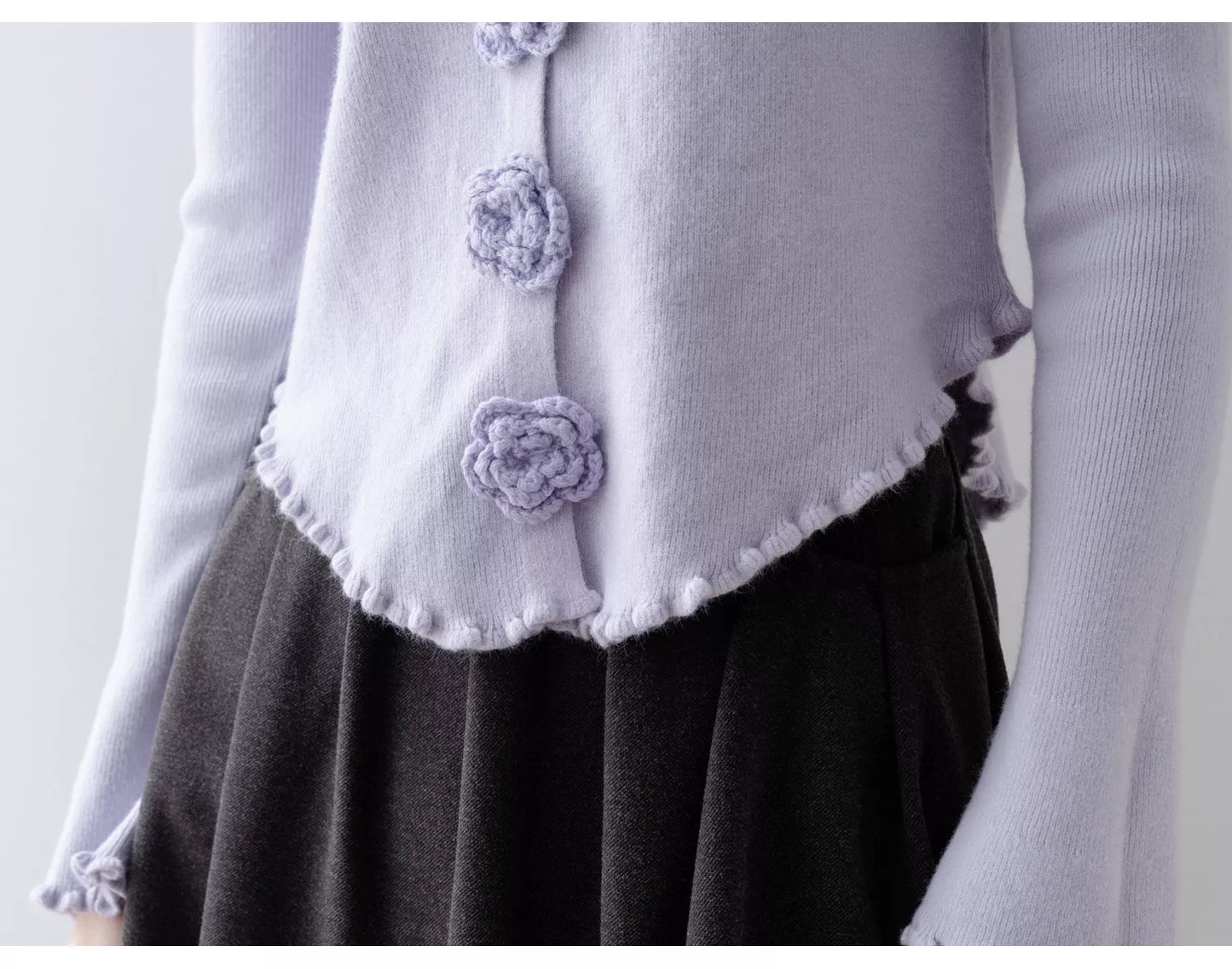 Elegantes, lila Stricktop mit Rundhalsausschnitt, floralen Details und Rüschen.