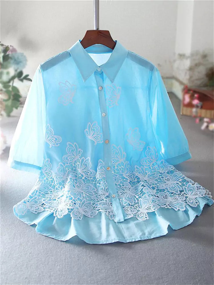 Blusa de encaje bordado con volantes en el bajo y mangas cortas