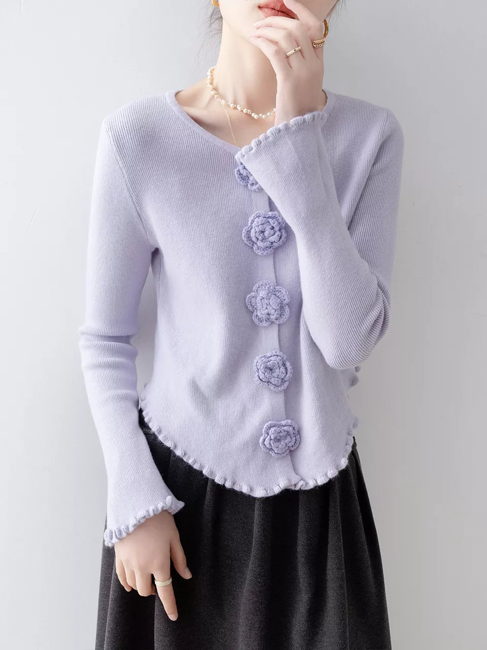 Elegantes, lila Stricktop mit Rundhalsausschnitt, floralen Details und Rüschen.