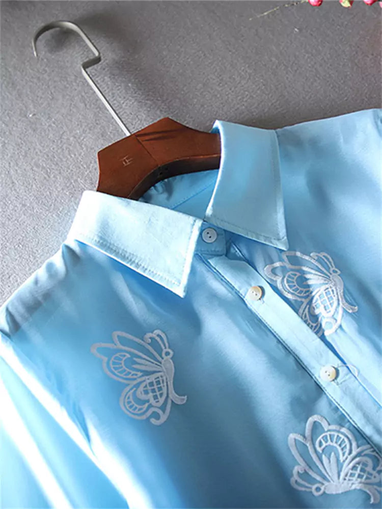 Blusa de encaje bordado con volantes en el bajo y mangas cortas