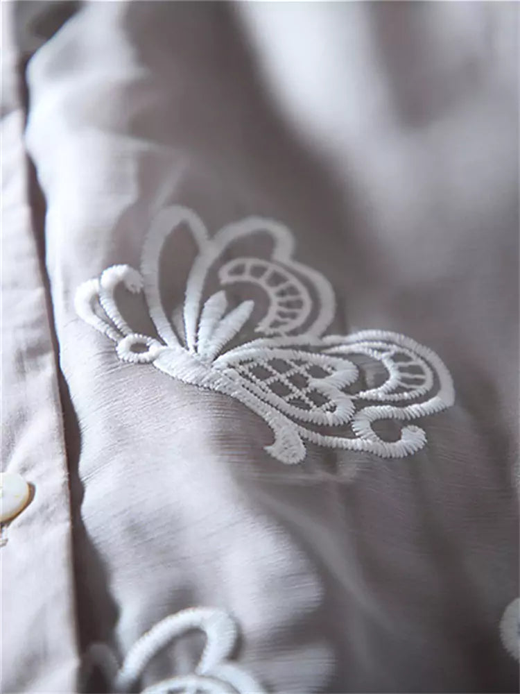 Blusa de encaje bordado con volantes en el bajo y mangas cortas