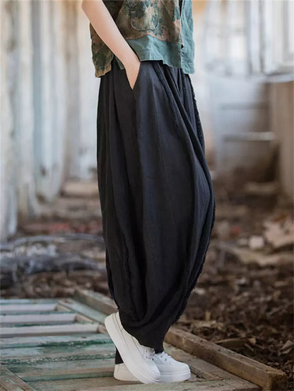 Pantalones vintage de tiro alto y pernera ancha tipo farol: corte holgado de ramio lavado con bajo sin rematar y silueta fluida.