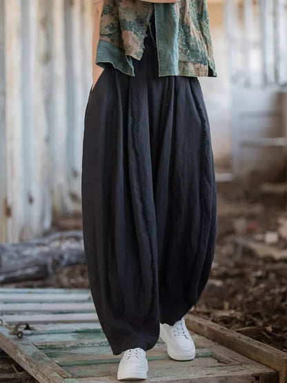 Pantalones vintage de tiro alto y pernera ancha tipo farol: corte holgado de ramio lavado con bajo sin rematar y silueta fluida.