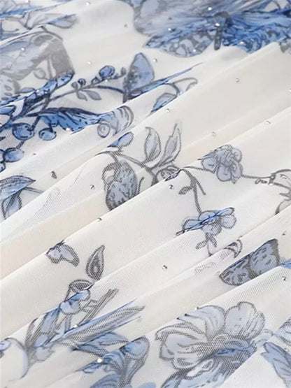 Aprikosenfarbener, geblümter, plissierter A-Linien-Tüll-Midirock in Midi-Länge mit Falten.