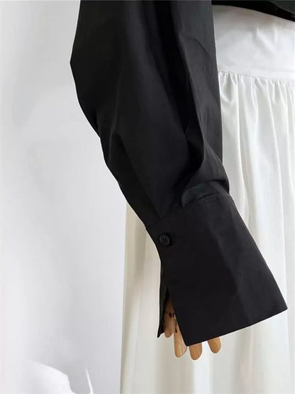 Schwarzes, einteiliges Hemd mit Fledermausärmeln, V-Ausschnitt und Stehkragen