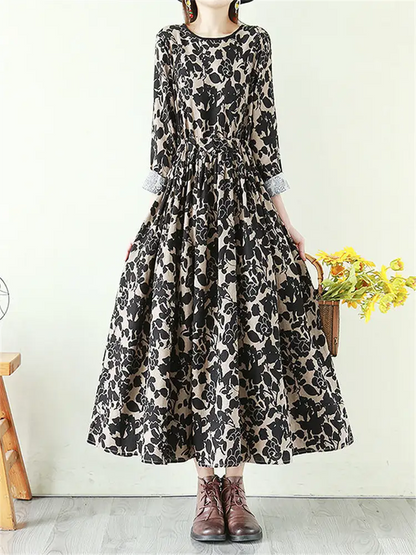 Vestido largo de lino con estampado floral fluido, cintura anudada y manga larga