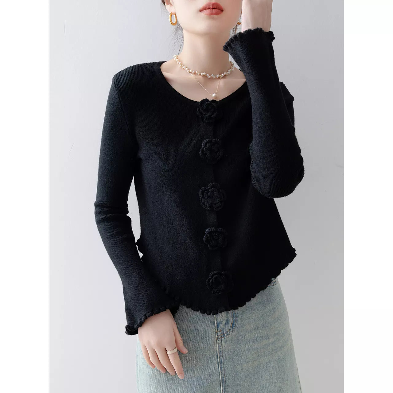 Elegantes, lila Stricktop mit Rundhalsausschnitt, floralen Details und Rüschen.